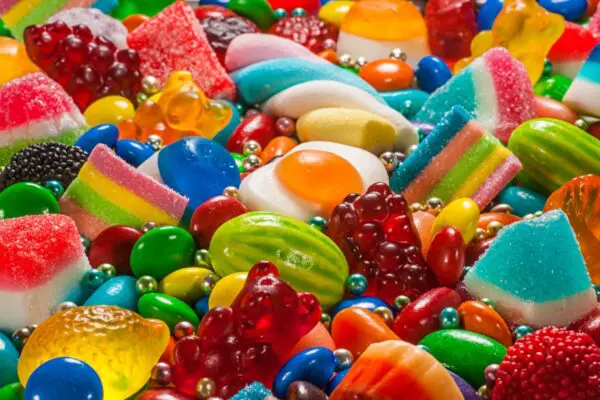 A colorful assortment of various candies, including gummy bears, jelly beans, and licorice, displayed closely together.
